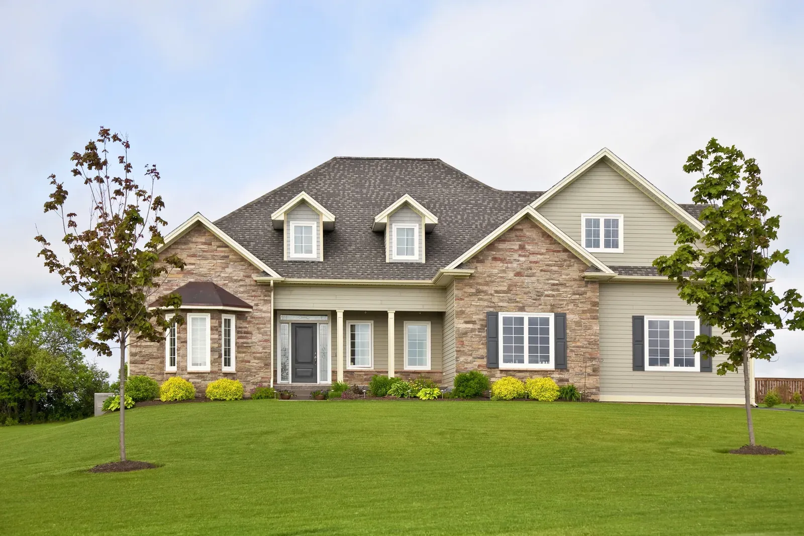 Newly built New England home with landscaped lawn
